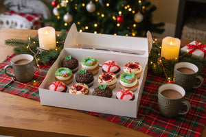 Box of assorted Christmas cupcakes with different designs and colours.