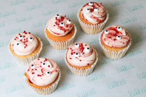 Strawberry Halloween cupcakes with vanilla sponge, pink strawberry buttercream, freeze-dried strawberries and spooky edible eyes.